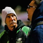In the fall of 2023, Laney coach John Beam speaks with Oakland Section commissioner Franky Navarro before the Silver Bowl, the annual McClymonds vs Oakland Tech game and the Oakland Athletic League football championship game at McClymonds High School in Oakland. Beam was shot on Thursday and has died at the age of 66. (Joseph Dycus/Bay Area News Group)